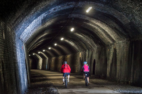 Cyclists riding through Cressbrook Tunnel