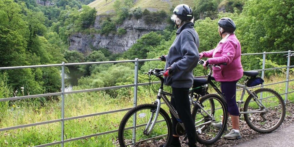 Two cyclists looking at view at Water-cum-Jolly on the Monsal Trail